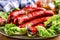 Sausage. Chorizo sausage. Raw smoked sausage with vegetable decoration.Lettuce salad herb rosemary tomato garlic olive oil