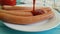 Sausage drops ketchup on the plate, slow-motion shooting