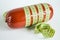 Sausage wrapped with green tape measure on white background close-up
