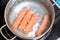 sausages are boiled in a pan in boiling water