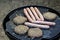 Sausages and burgers sizzling on a barbecue griddle plate