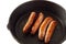 Sausages cooking cast iron pan