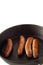 Sausages cooking cast iron pan