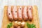 Sausages for frying, garlic, parsley on a wooden cutting board