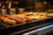 sausages sizzling on a modern rotisserie grill in a busy restaurant