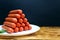 Sausages on a white plate stacked in the form of a tower