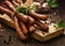 Sausages on a wooden rustic table with addition of fresh aromatic herbs and spices, natural product from organic farm, produced b