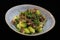 Saute Brussels sprouts  with beef bacon in a serving bowl with black background