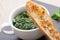 Sauteed garlic spinach dish, baked bread slice with melted che