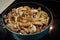 Sauteing mushrooms and onions in a frying pan with oil, seasoning, and steam