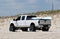 Savage Ditch, Delaware, U.S - July 4, 2023 - A white Ford truck with a kayak and surf fishing beach permit driving on the sand