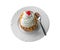 Savarin cake with cream and syrup, silver spoon, white plate