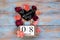 Save the date block calendar for International Womens day, March 8, with chalkboard, next to roses flowers, on blue