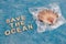 Save the ocean text on blue bakground with sea shell on top of plastic bag, respect the environment  concept