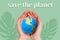 Save the planet. Woman& x27;s hands hold a small ball of the planet Earth, close-up. Green background with a silhouette