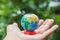 Save the world - globe in woman hand with tree bokeh backdrop