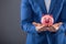 Saving money. Businesman holding pink piggy and putting coin into piggy bank