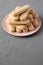 Savoiardi or ladyfingers cookies on pink plate on concrete surface, low angle view