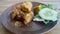 Savor Ayam Penyet, East Javanese fried chicken, pounded for tenderness, served with sambal, slice of cucumber, fried tofu, and