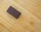 Savor Every Bite: A Single Piece of Chocolate on a Warm Wooden Background