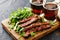 Savoring a delicious steak and fresh greens meal with dark beer on a rustic wooden board