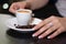 Savoring the Moment: Girl\\\'s Hand Holding Espresso Coffee Cup in a Cozy Bar