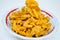 Savory and delicious bitter melon chips in a bowl on a white background.