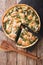 Savory food: sliced tart with salmon, spinach and cream close-up. vertical top view