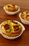 Savory mini quiches tarts on a wooden board. Baked homemade flaky dough pies. Ready for eat. Copy space