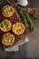 Savory mini quiches tarts on a wooden board. Flaky dough pies.