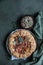 Savory tomato tart, open pie or galette with tomatoes and cheese decorated with aromatic herbs on green background. Top view