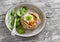 Savoury rustic pumpkin pie and fresh spinach on rustic light wood table.