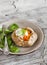 Savoury rustic pumpkin pie and fresh spinach on rustic light wood table.