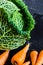 Savoy cabbage with baby chantenay carrots. Close up on slate