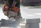 Sawing concrete with a circular hand saw on road construction.