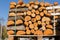 Sawn firewood, tightly stacked to each other, laid out on a pallet, against the background of a sky