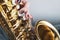 Saxophone girl player hands. Saxophonist playing jazz music. Alto sax musical instrument closeup. Painted nails