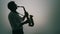 Saxophone player over a light grey background.