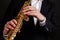 Saxophonist in black classic suit playing soprano saxophone in jazz orchestra close-up