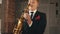 Saxophonist in dinner jacket play on golden saxophone at stage. Jazz artist.