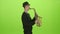 Saxophonist playing on the gold musical instrument. Green screen