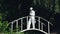 Saxophonist in a white frock coat and hat playing on the bridge.