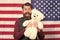 Say it loud for country proud, happy Independence day. Bearded man holding teddy bear on Independence day. Happy hipster