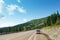 Sayany Mountains. The track. Summer sunny day. The car stopped on the roadside