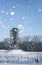 Scaffold around the water tower in field in front of forest in s