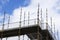 Scaffold platform and poles in blue sky at high level of construction building site