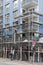 Scaffolding builders assemble a scaffolding in front of a blue house