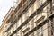 Scaffolding on a generic old tenement house, renovated historical building facade detail, closeup, nobody. Restoration industry