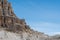 Scale.  Rock formation dwarfs lone hiker on ridge.  Dolomites, Italy