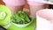 On the scales is a cup with mint. A woman adds mint leaves to her. The process of making Swiss roll. Close-up shot